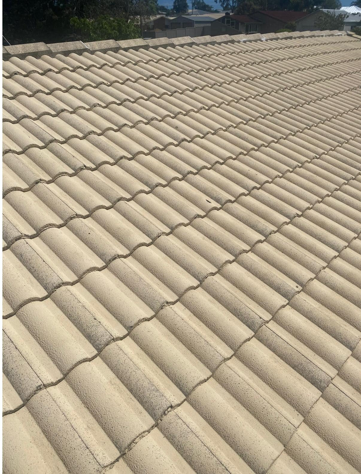 Old and dirty beige tile roof prior to professional roof cleaning and painting